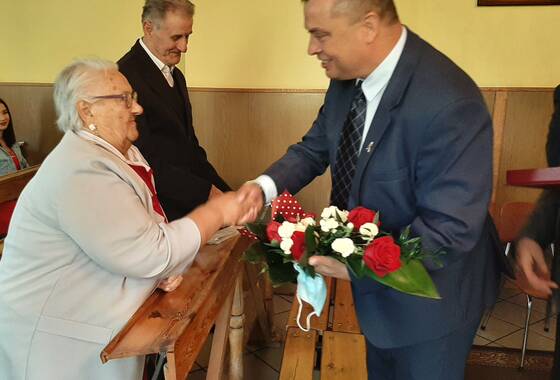 Zdjęcie z uroczystości Diamentowych Godów. Małżeństwo odbiera gratulacje od Przewodniczącego Rady Gminy Gaworzyce - Edwarda Białka.