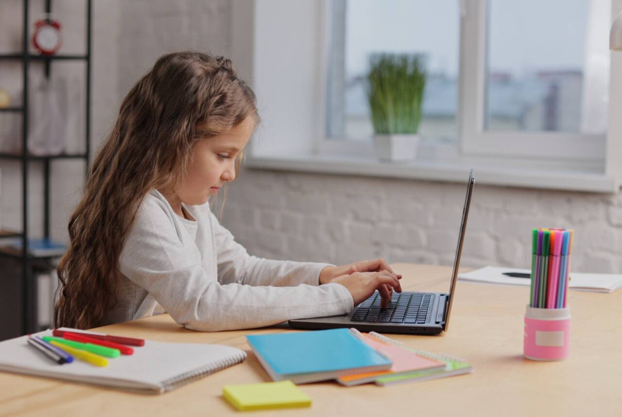 mała dziewczynka uczy się korzystając z laptopa, zdjęcie przykładowe