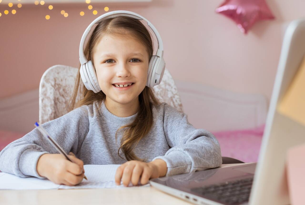 zdjęcie okładkowe - dziewczynka przy laptopie uczy się