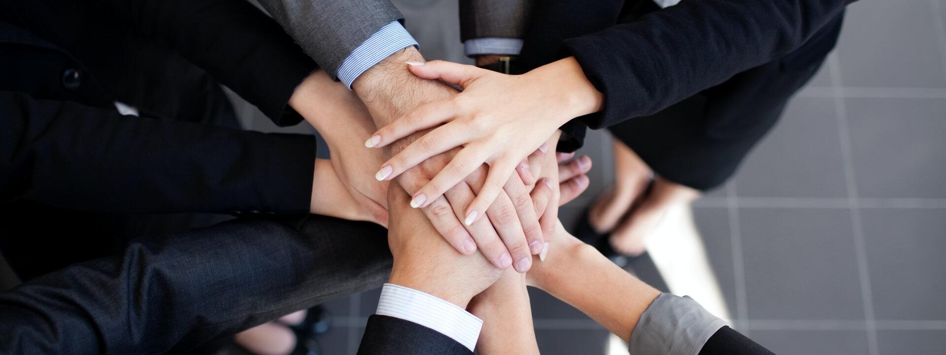 przykładowe zdjęcie zespołu składającego razem ręce w myśl "razem damy radę"