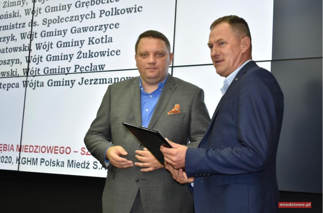 Zdjęcie z portalu miedziowe.pl - przedstawia Wójta Gminy Gaworzyce oraz Marcina Chludzińskiego - prezesa KGHM Polska Miedź w trakcie przekazania umowy darowizny.