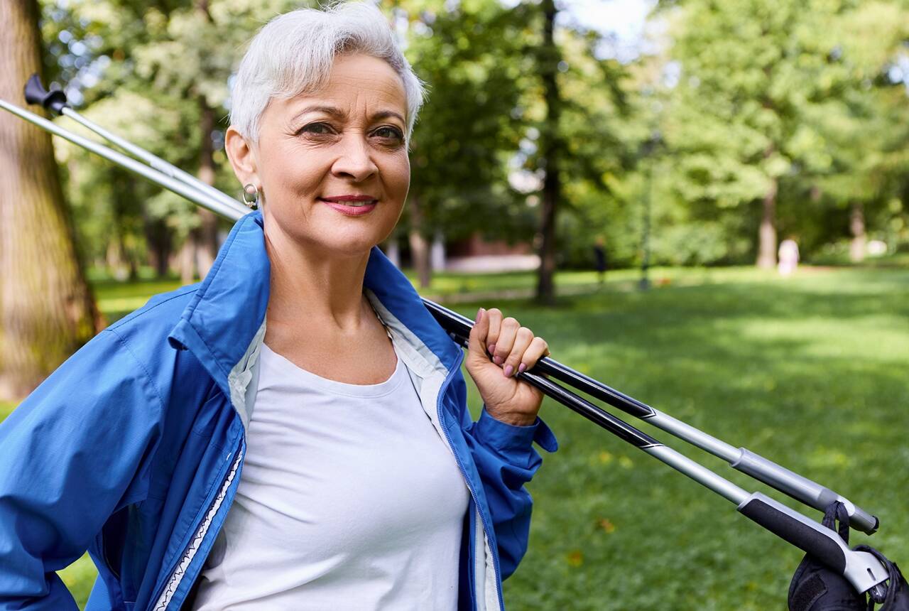 starsza kobieta z kijkami nordic walking